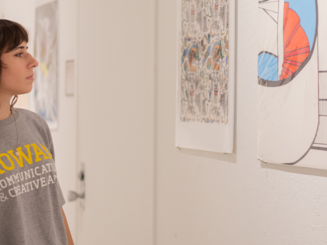 Gabrielle Kennedy looks toward some of her artwork on the walls.