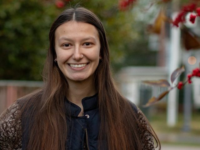 Rowan University Law and Justice major Kayla stands outside on campus near Hollybush Mansion.