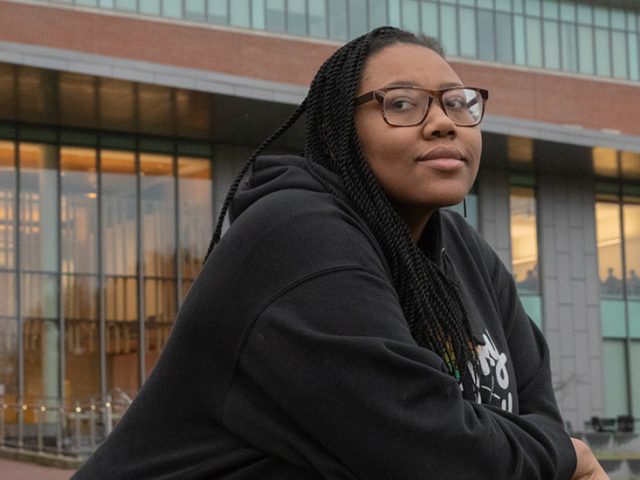 Rowan University Public Health and Wellness major Jasmine stands outside Rowan's Business Hall.