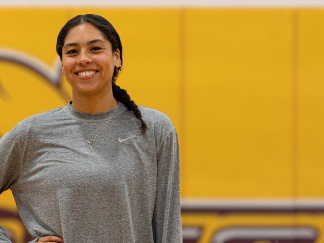 Rowan University Health and Physical Education major Adrianna is standing out front of the PROF logo in her basketball gear.