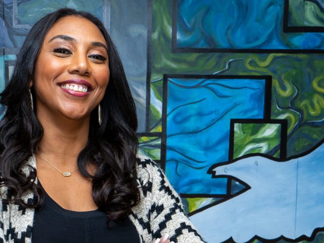 Janine poses in front of a mural.