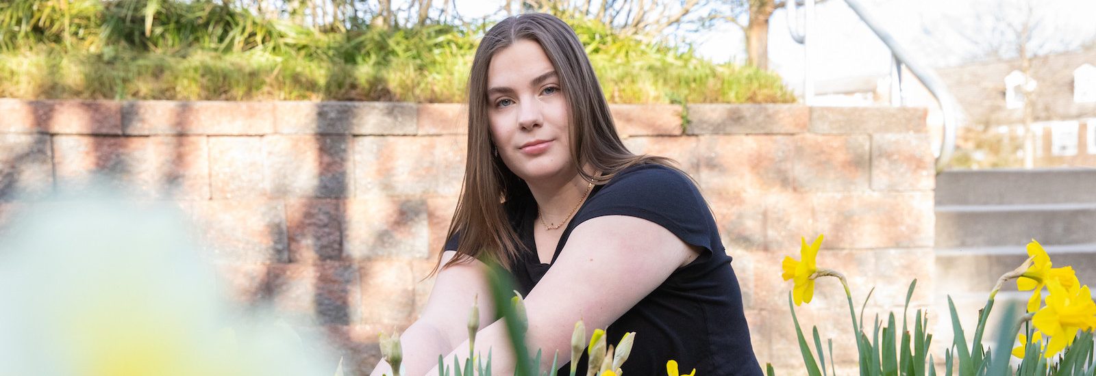 Abigail Cassino sits in a daffodil patch.