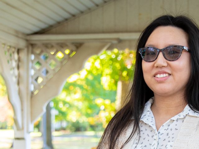 Suzie is standing in a pavilion and smiling at the camera.