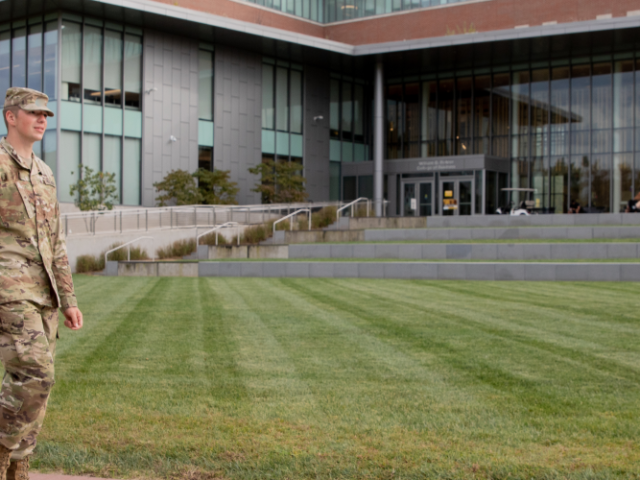 Three military students walking and talking outside the Business Hall.