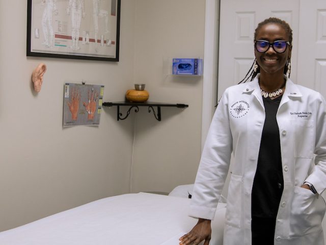 Dr. Penick stands in her office wearing a white physician coat.