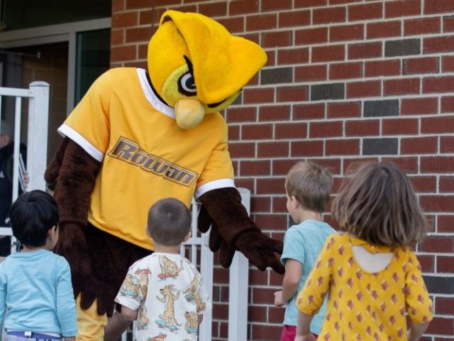 Prof mascot playing with kids.