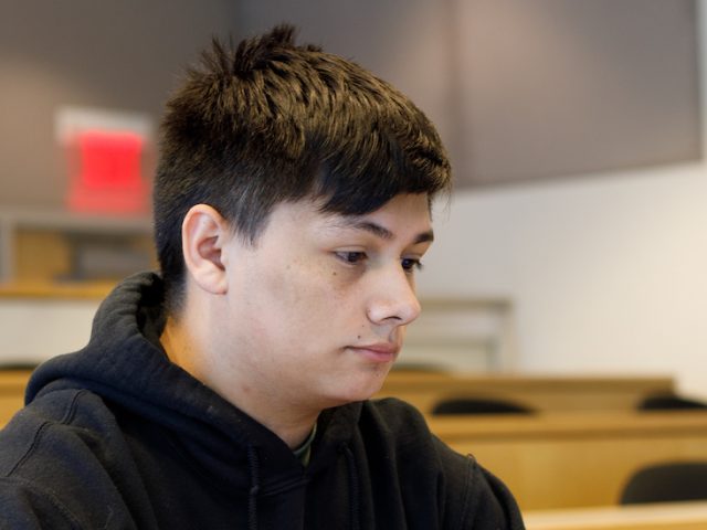 Paul sits at a desk studying on his laptop.