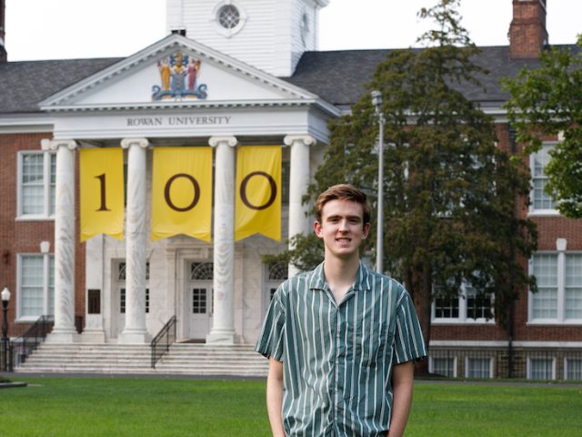 Landon stands in front of Bunce, decorated with the 100 year banner.