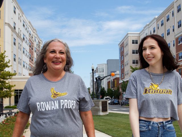 A mother and daughter walk on Rowan Boulevard smiling.