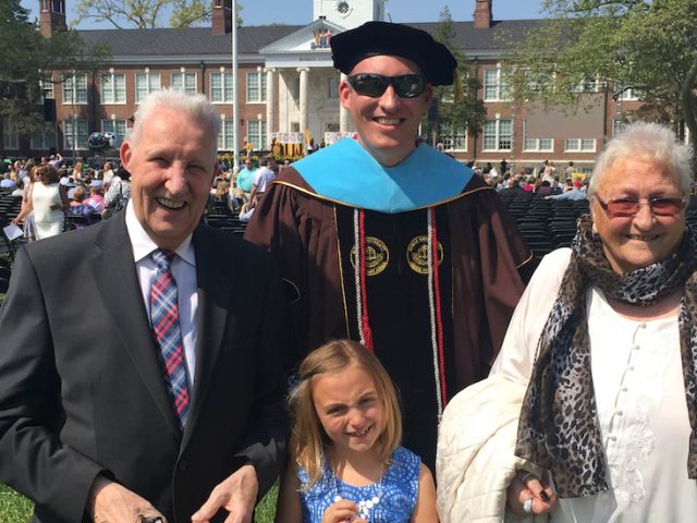 Tobi standing with his family after graduating in 2016.