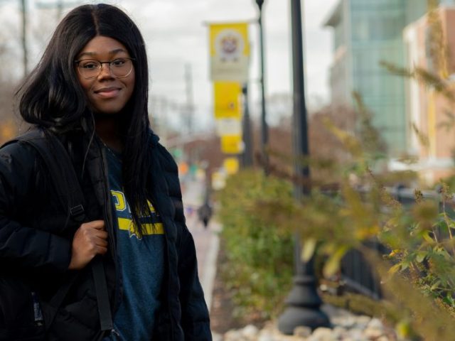 Asiya stands outside on campus on a chilly day.