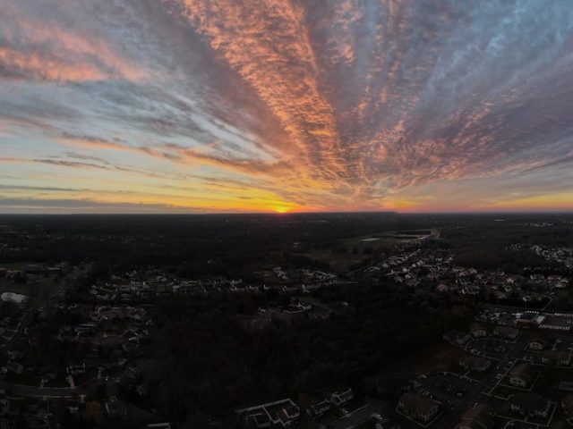 Dramtically colored sunset over the town of Glassboro, as seen from a drone.