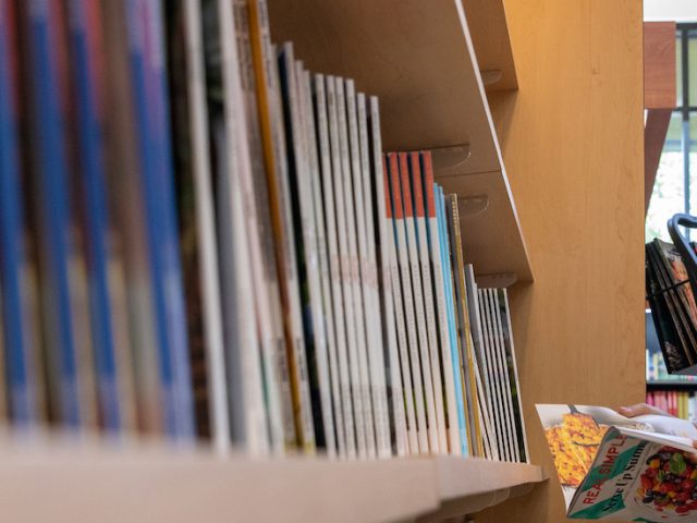 A female student browses a bookshelf at the bookstore.