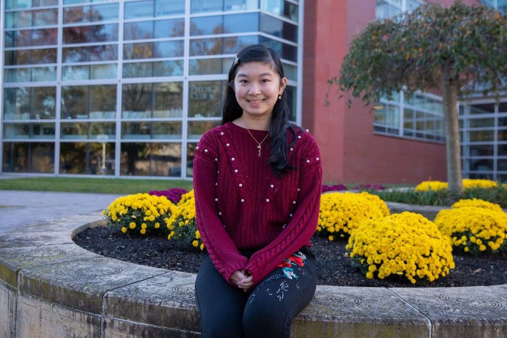 Cindy Nguyen sits in a formal pose outside of Science Hall. 