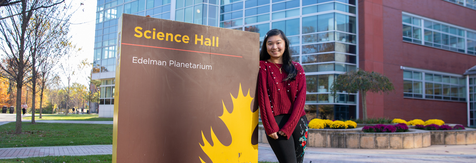 Cindy stands next to the Science Hall sign.