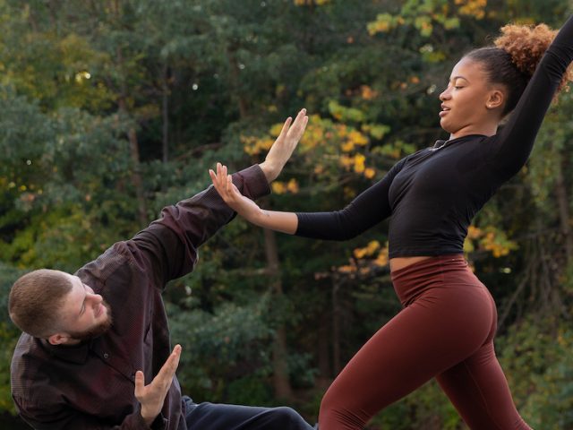 Two dancers in mid-pose outdoors.