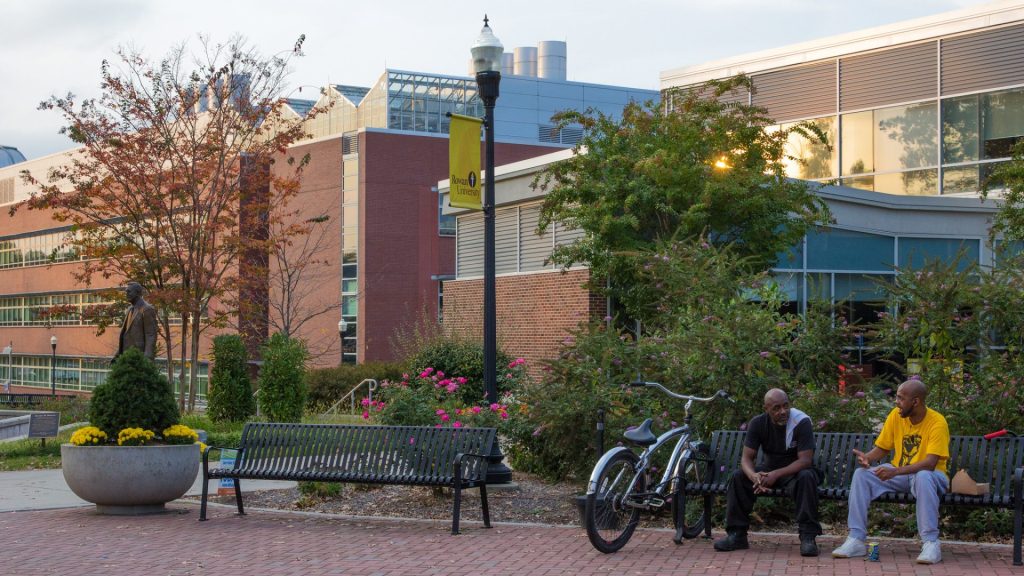 Two people sitting and talking outside of Savitz Hall.