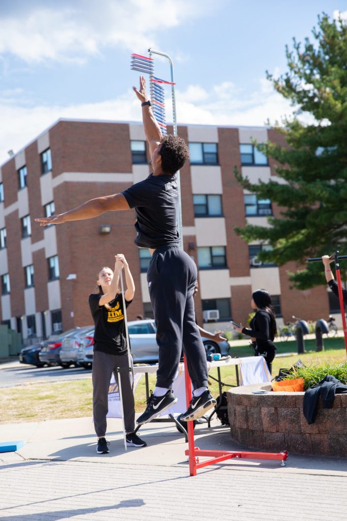 A student testing his vertical jump height with the Exercise is Medicine club.