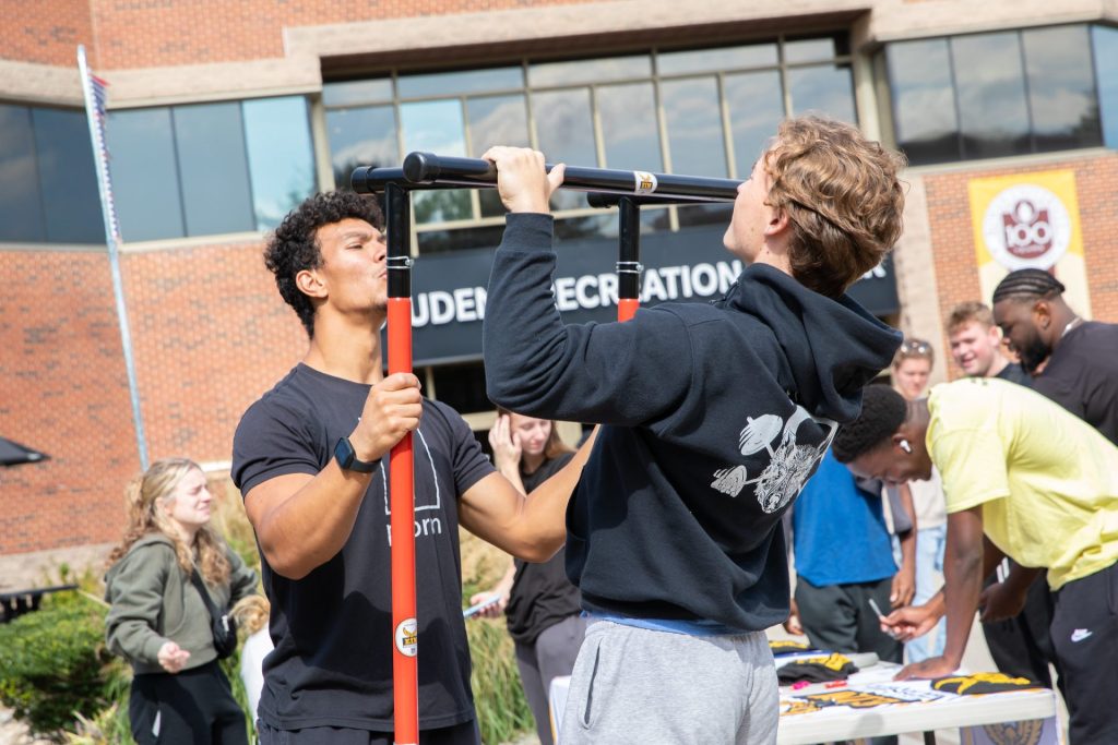 Exercise is Medicine club students testing other students with pull up challenges. 