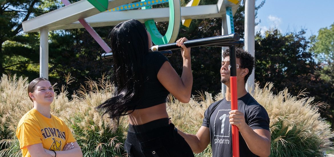 Rowan University students engage with the Exercise is Medicine club on campus, trying various physical feats such as pull ups and balance tests.