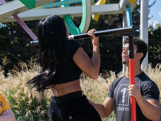 Rowan University students engage with the Exercise is Medicine club on campus, trying various physical feats such as pull ups and balance tests.