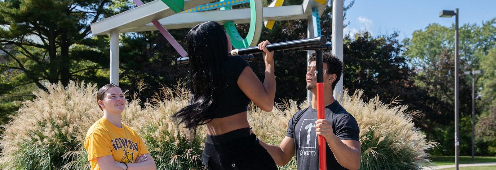 Rowan University students engage with the Exercise is Medicine club on campus, trying various physical feats such as pull ups and balance tests.