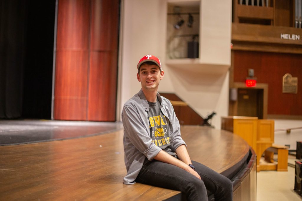 Connor Shields sitting on the Pfleeger Concert Hall Stage