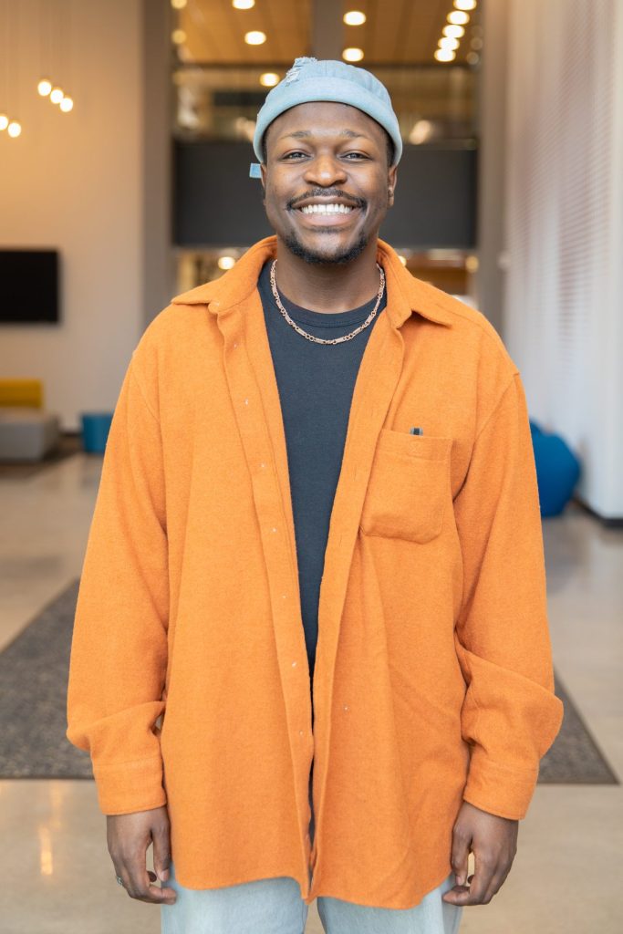 Vocal performance major Moses standing inside the Wilson Hall Dance Studio lobby at Rowan University. 