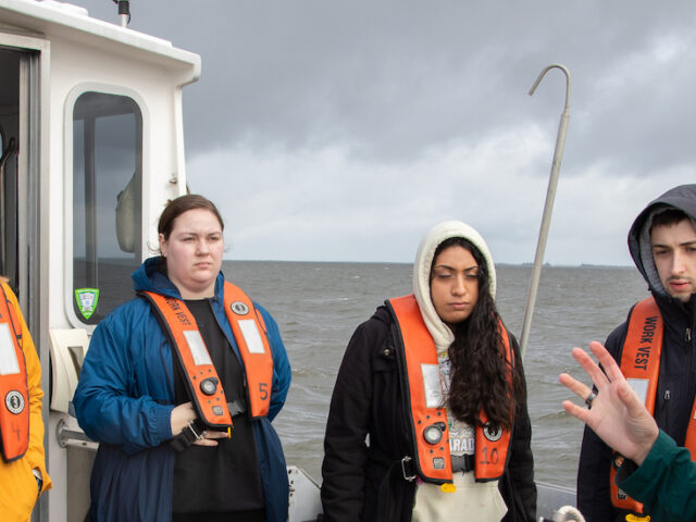 A group of Rowan environmental science students on a boat for their Oceans class.