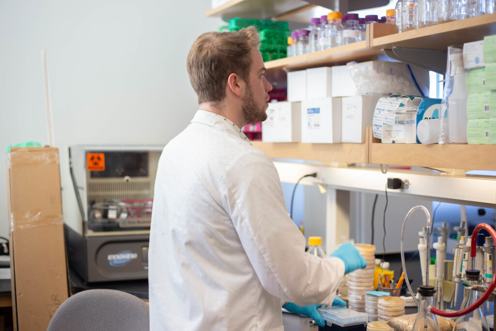 Rowan University biological sciences major Brian Libby peers at what's on the counters in a lab. 