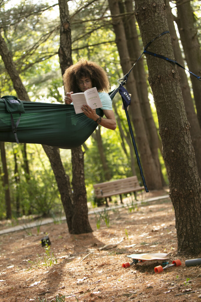 A poet reads in a hammock. 