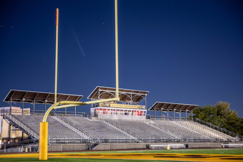 A creative photo, you see a light white trail of a comet appearing to split the uprights of the football goalposts on the football field at Rowan University. 