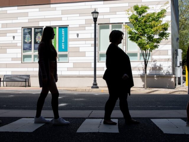 Rowan University professor and three students recreate the iconic Abbey Road cover from the Beatles, walking across the street from the advertising building.