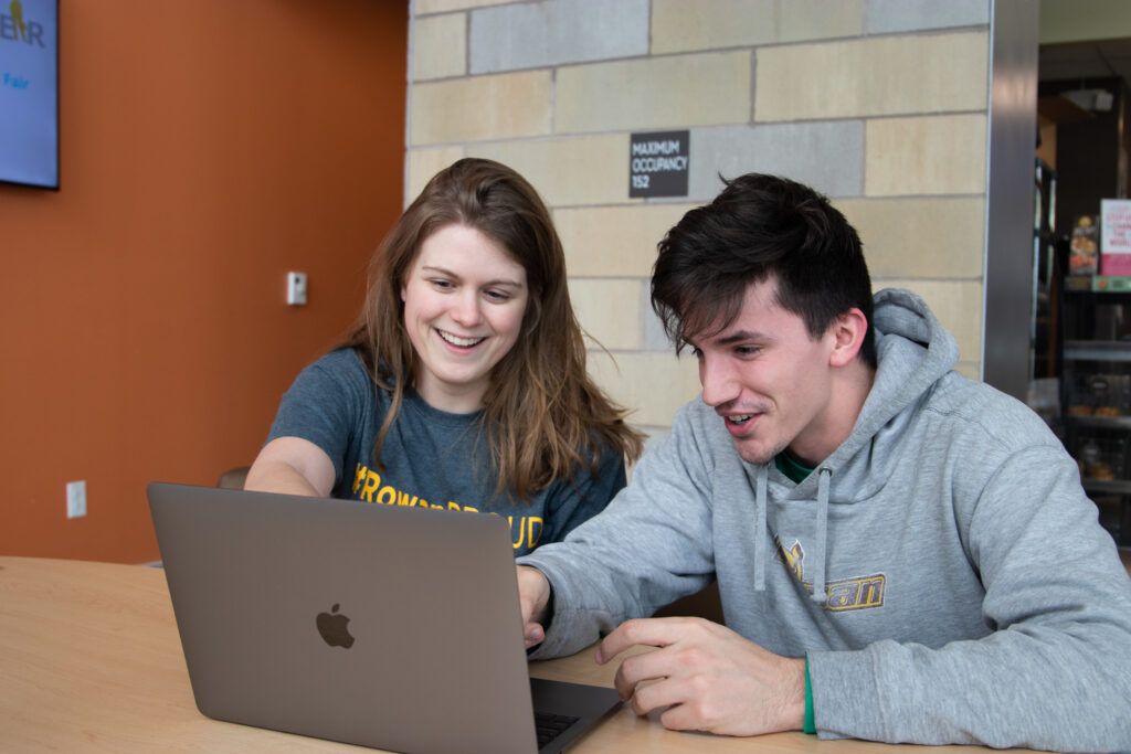 Two students collaborating in an Online Master's in Engineering Management program