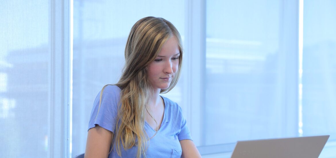 Student studying for an online healthcare administration degree on a laptop