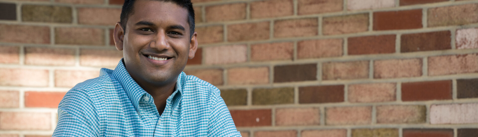 Smiling student representing success in an online psychology degree program.