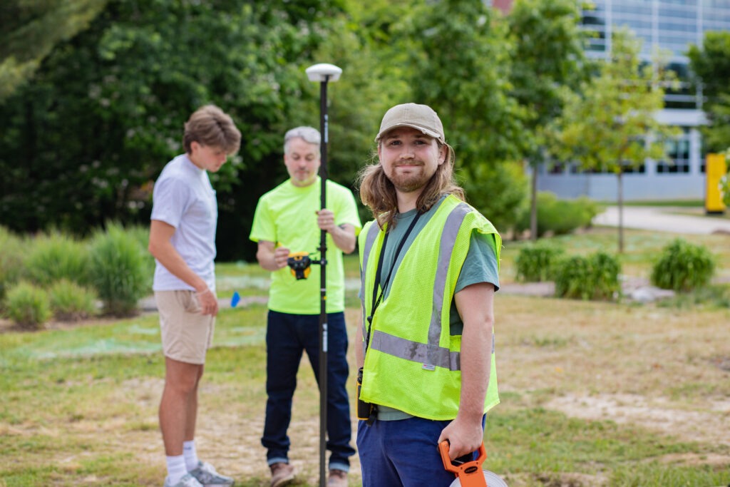 Construction management students gaining hands-on field experience with surveying equipment