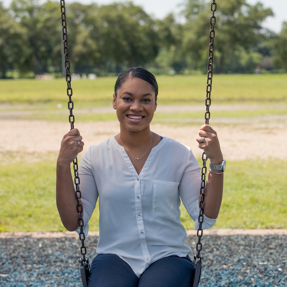 Rowan wellness degree student sitting on a swing smiling