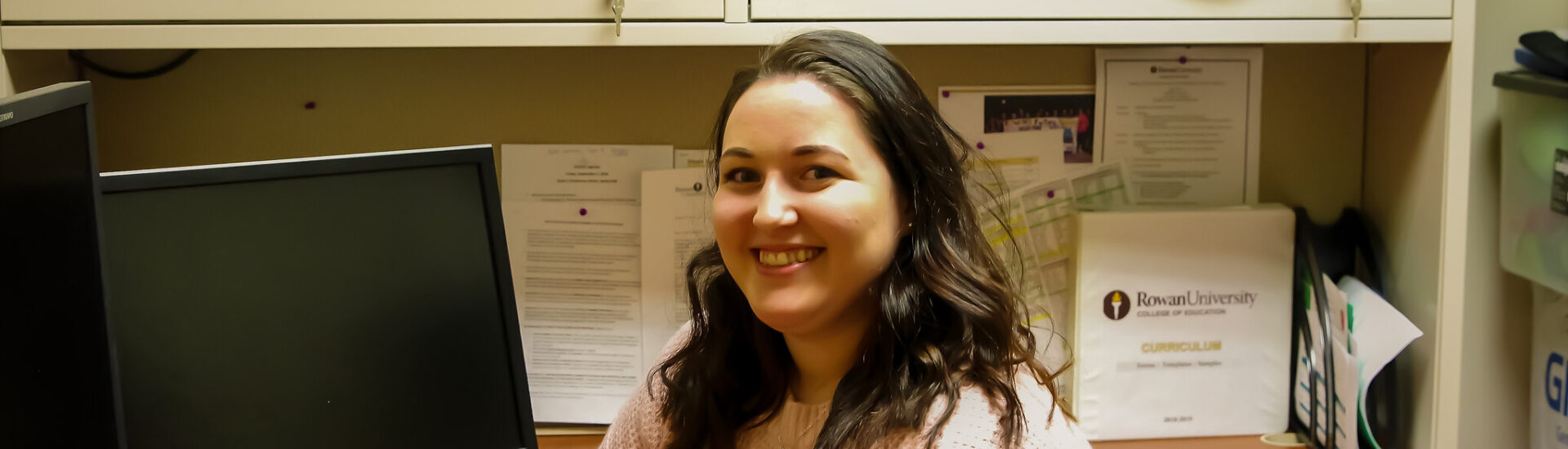Woman in office setting representing career outcomes with a master’s in education administration from Rowan University.