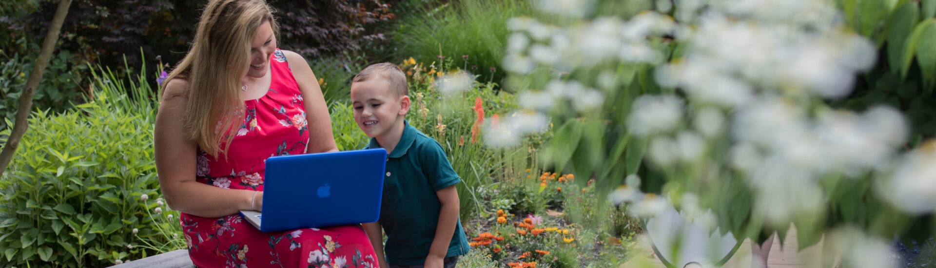 Online MBA student doing coursework on laptop with child.
