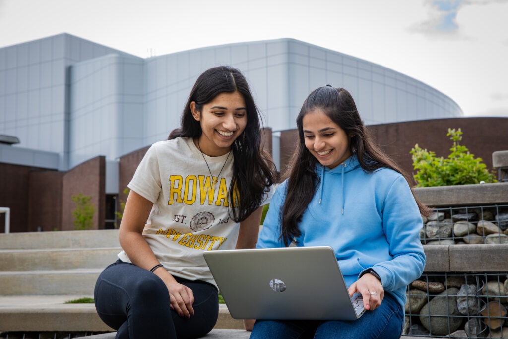 Students studying outside for their online masters in cybersecurity