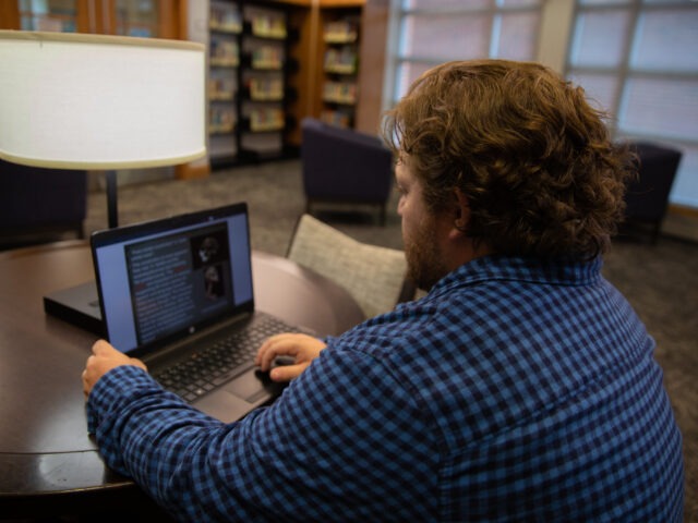 Student doing coursework for his online liberal arts degree