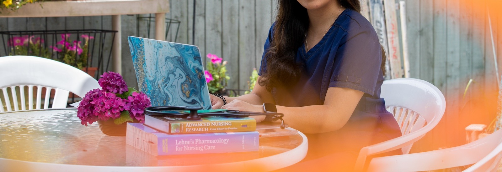 A close up of a master of science in nursing student studying outside.