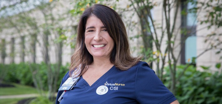 An RN to BSN nurse stands outside her healthcare setting.