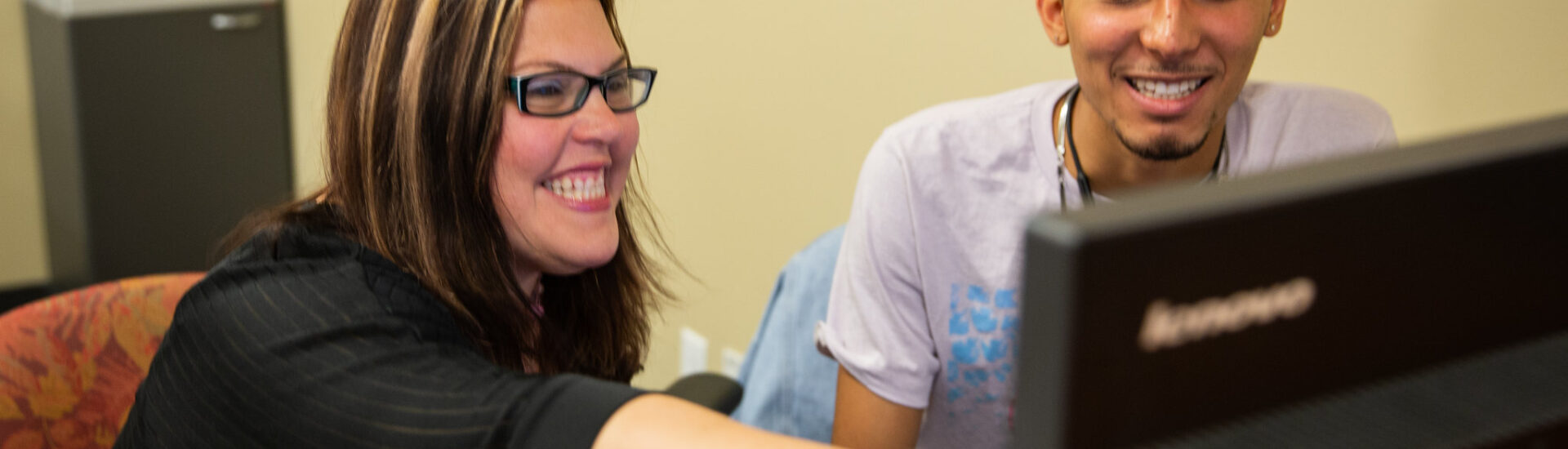 Teacher supporting a student through online learning in a special education certification program.