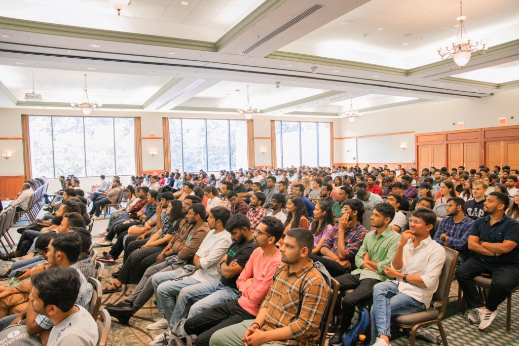 A room full of people as seen from the side, at nternational Students Orientation held by the Rowan International Center.