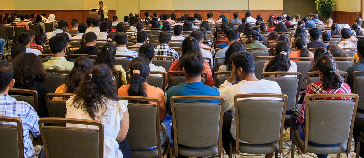 A room full of people, as seen from the back of the room, at International Students Orientation at Rowan University.