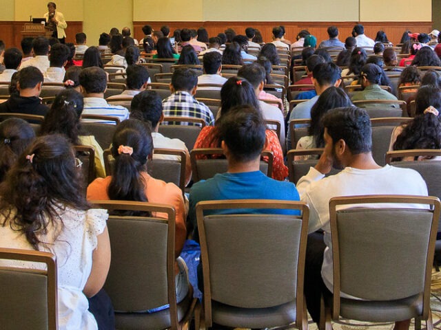 A room full of people, as seen from the back of the room, at International Students Orientation at Rowan University.