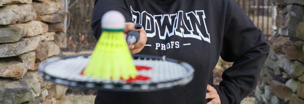 A close up of a badminton birdie resting on a racket at Rowan University.