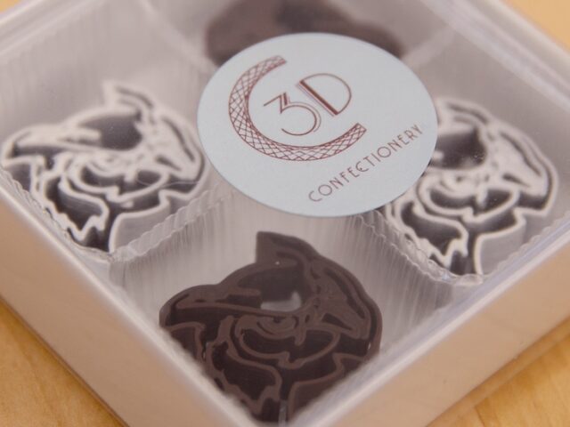 A close up of a box of 3D printed chocolates in the shape of Rowan University's mascot.